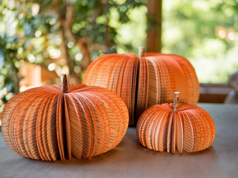 three orange book pumpkins in small, medium, and large