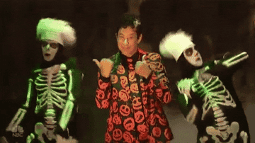 Tom Hanks as David S. Pumpkins dancing alongside two SNL cast members in skeleton suits