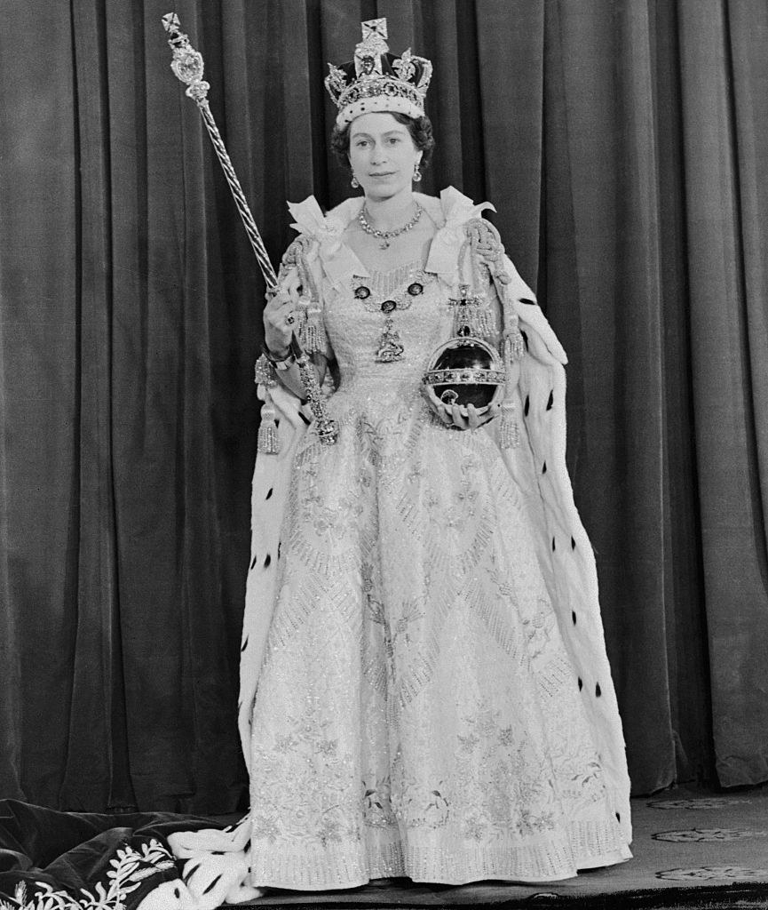 Queen Elizabeth in a gown, a fur coat, and a crown