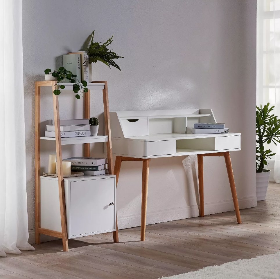 White desk with wooden legs next to matching shelf
