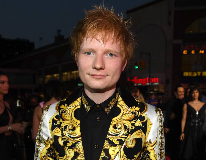 Ed wears a white blazer with gold patterns
