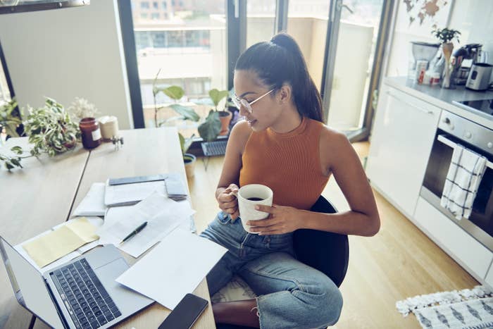 Woman looking at her finances with a laptop and phone