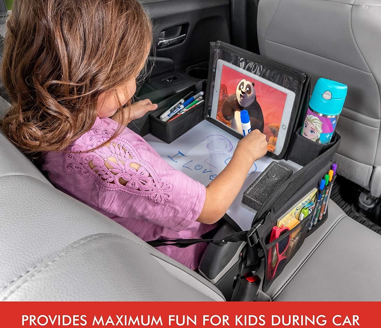 A model watching the tablet and coloring on the table in a car