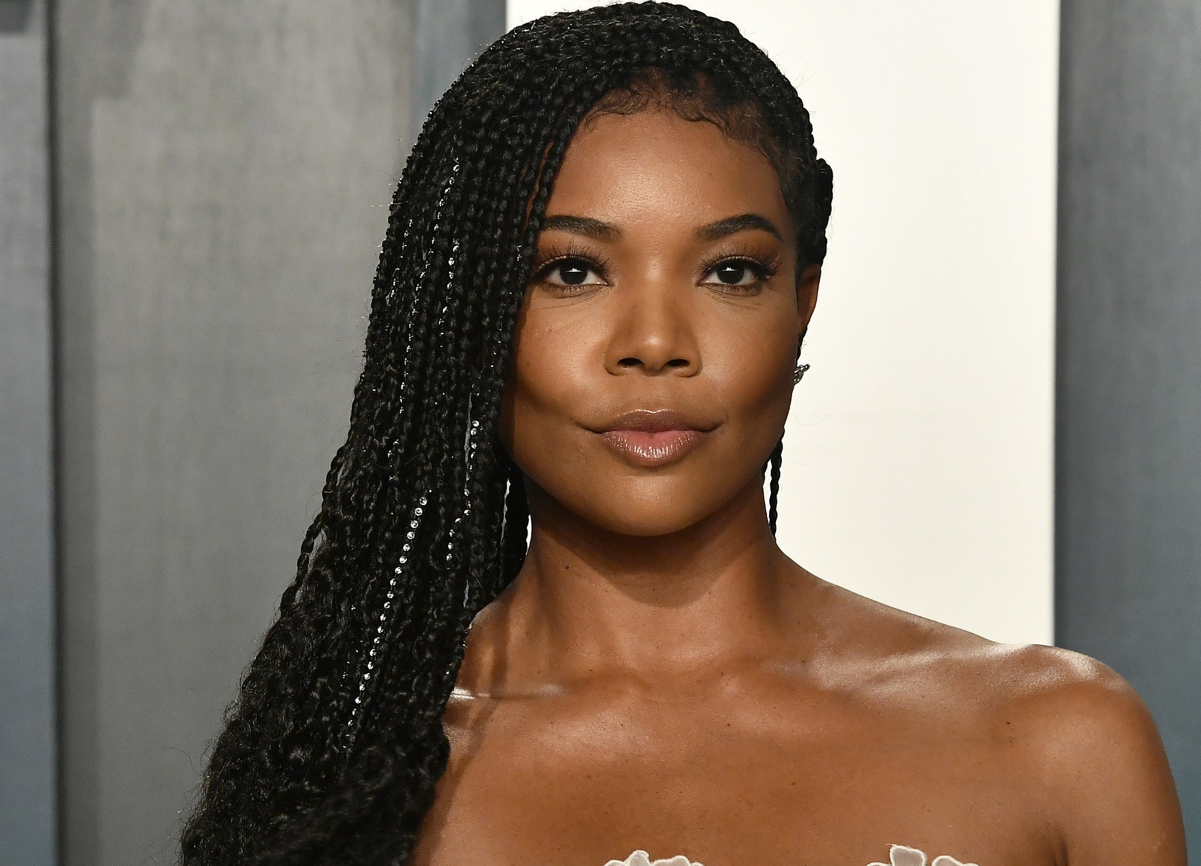 A close up of Gabrielle at an event with her braided hair pushed to one side