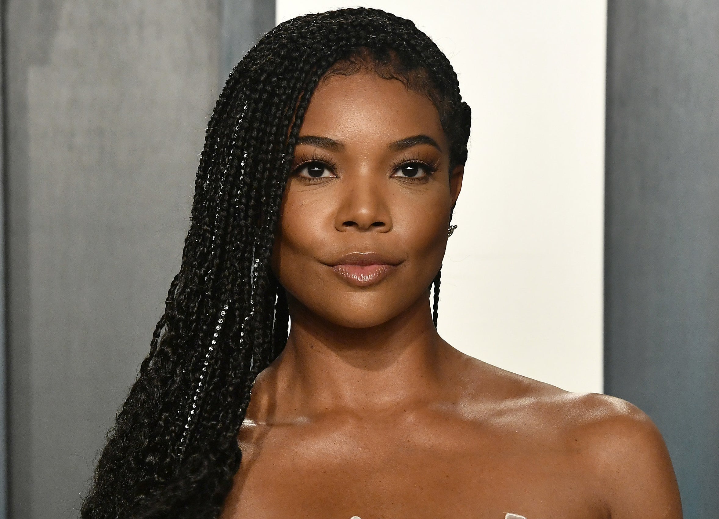 A close up of Gabrielle at an event with her braided hair pushed to one side