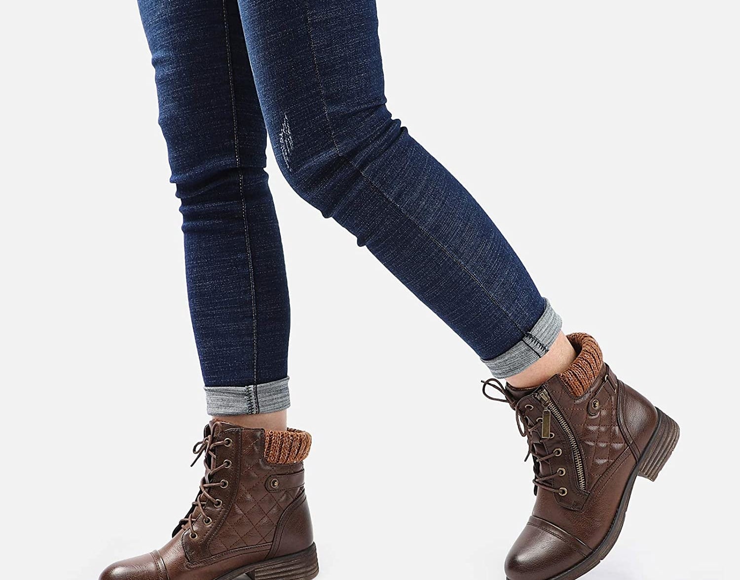 Model wearing the brown boots, which have a quilted side panel and elastic back