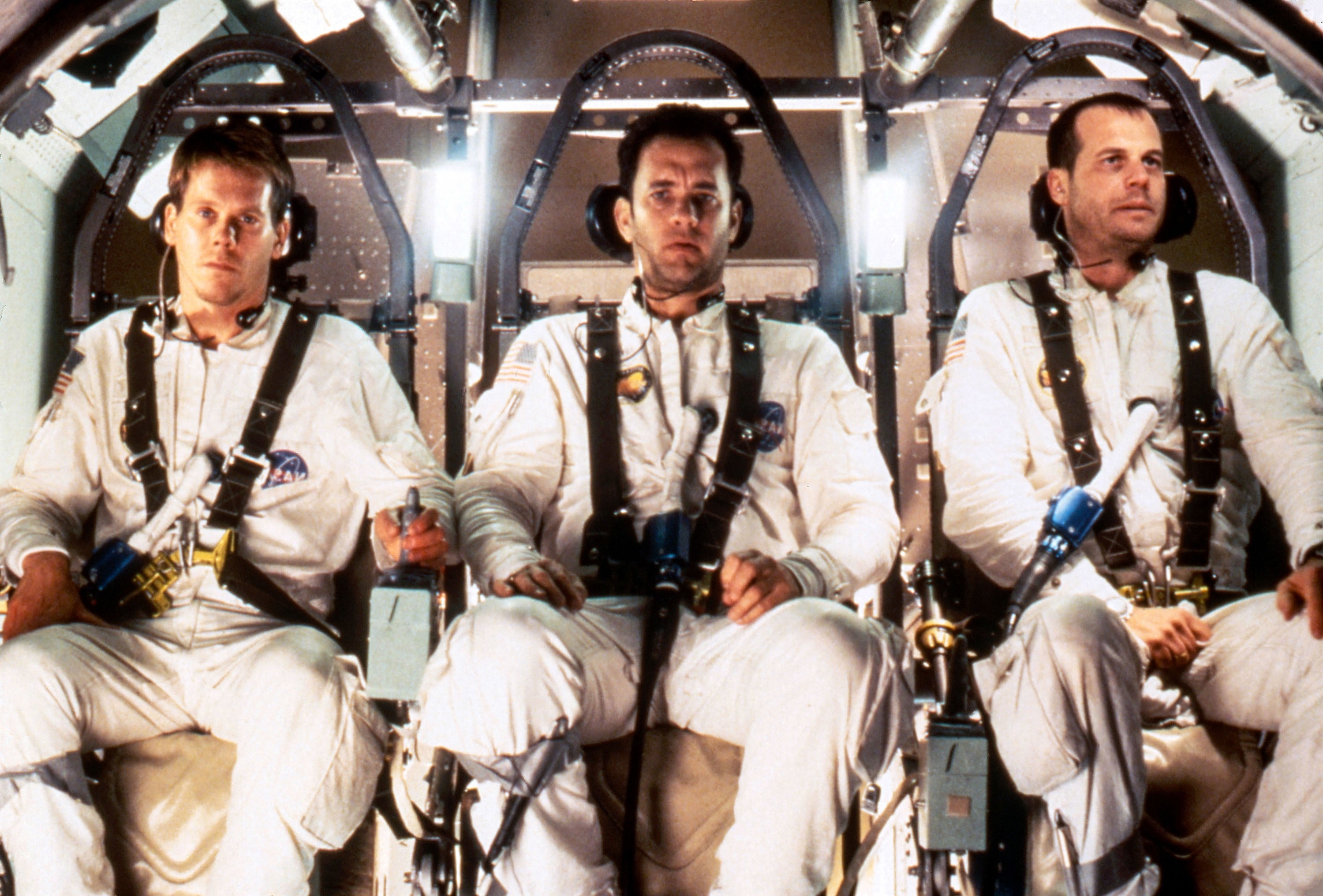 Fred Haise, Jack Swigert, and Jim Lovell wearing their NASA uniforms in the space shuttle in the film