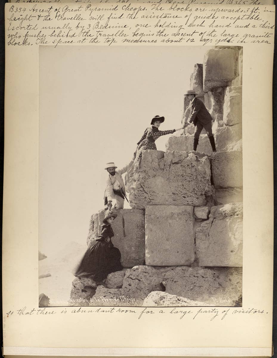 Four people climbing up the pyramids in Egypt