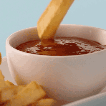 An animated gif of a fry dunking in a bowl of ketchup.