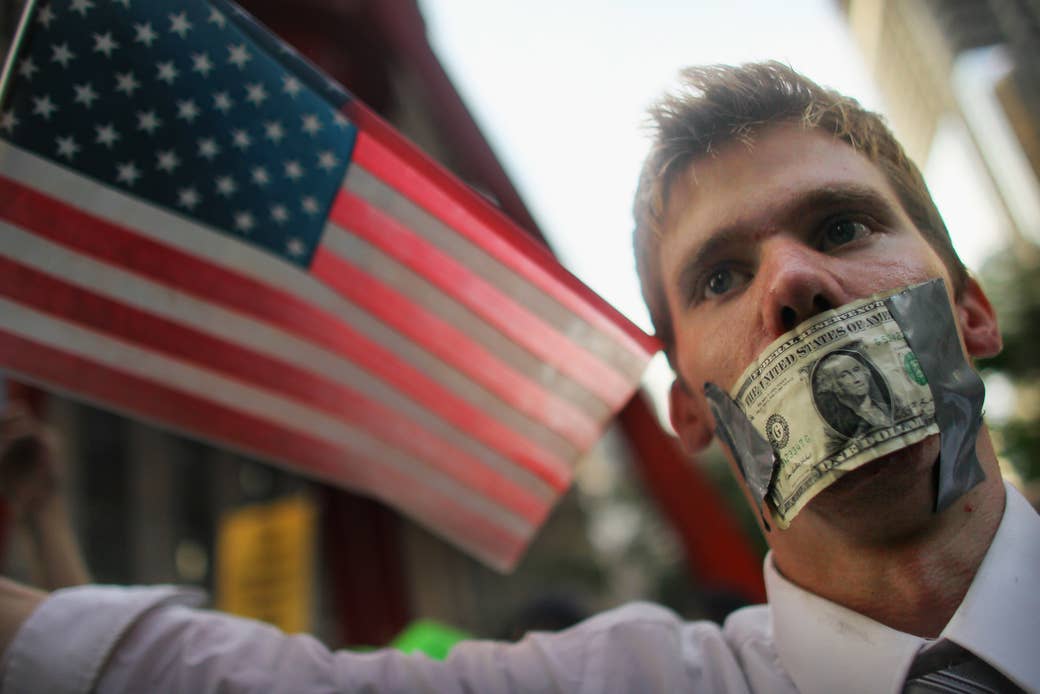 A protester wears a dollar bill over his mouth