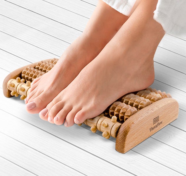 A person with their feet on the massage roller