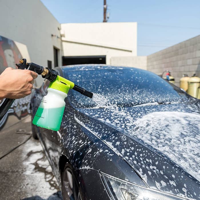 Model using foam cannon to wash car