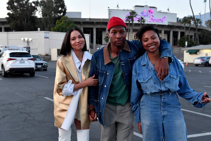 Jurnee, Jonathan Majors, and Misha Green taking a photo in a parking lot