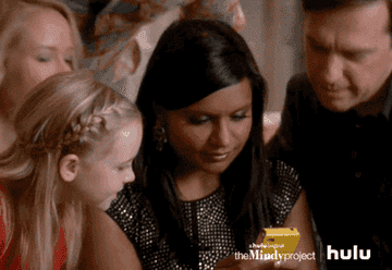 Mindy Kaling texting and nodding her head yes