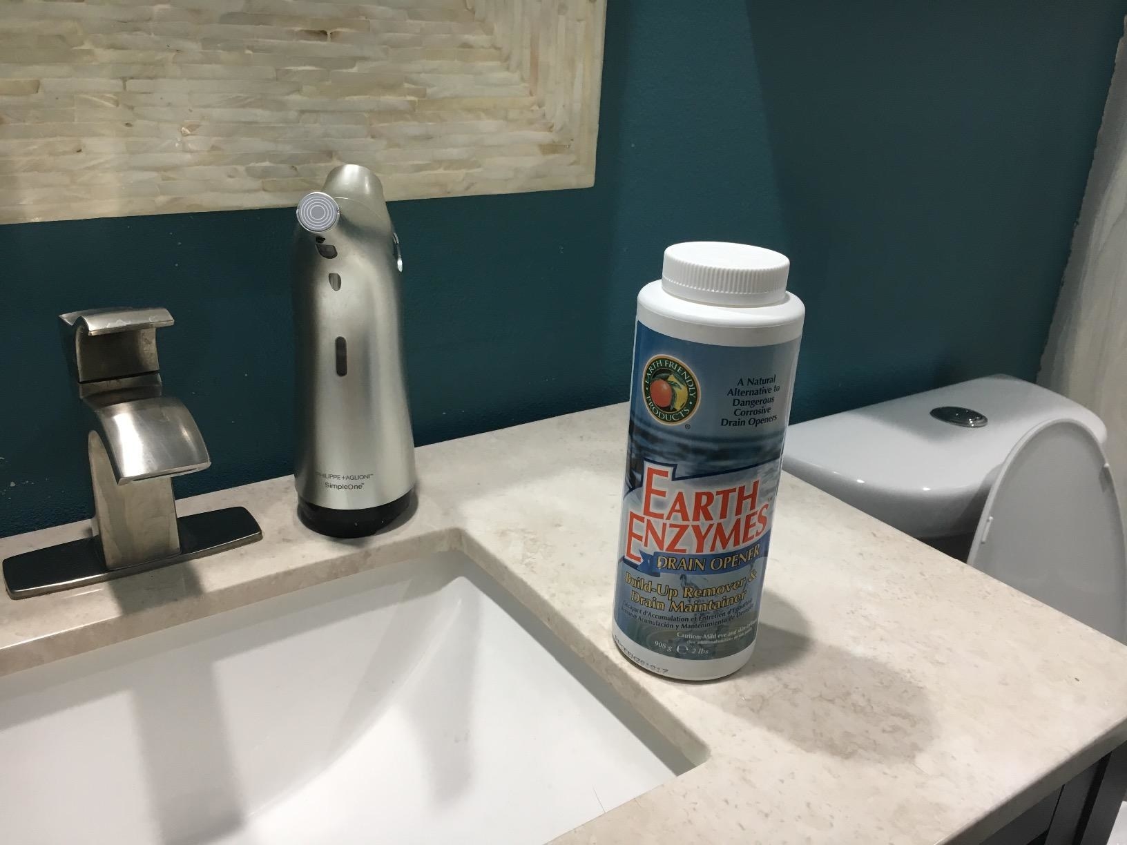 reviewer image of a bottle of earth enzymes on a bathroom sink counter