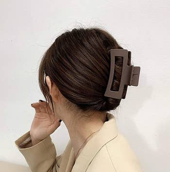 a model wearing a brown claw clip