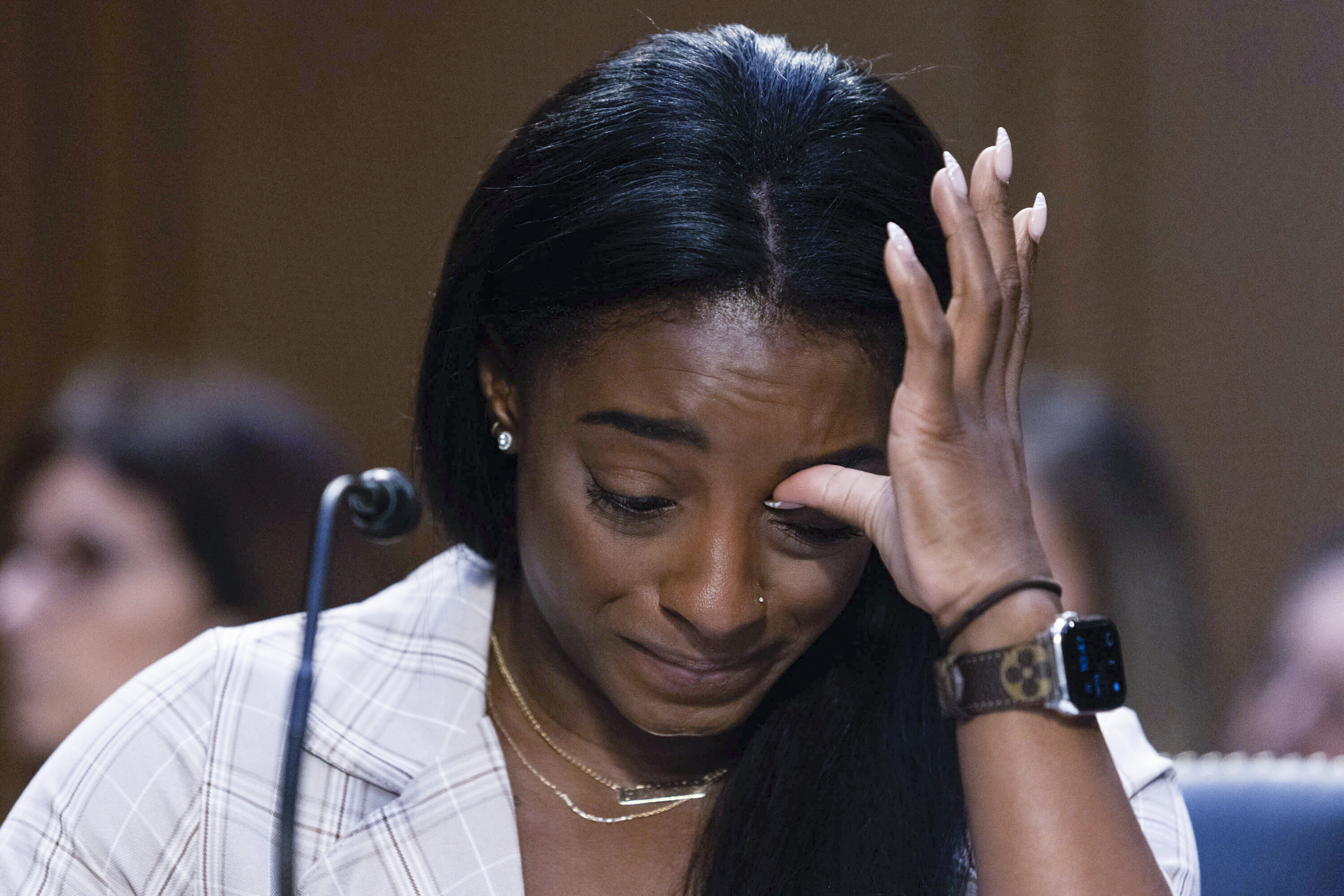 Biles wipes a tear from her eye during her testimony
