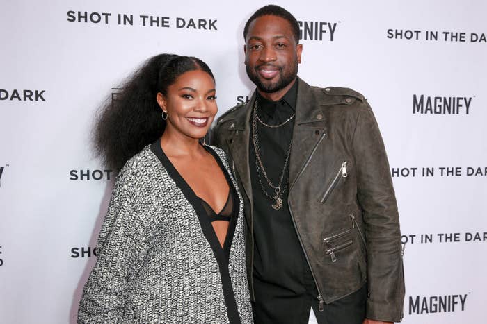 Gabrielle and Dwyane smiling as they pose on a red carpet together