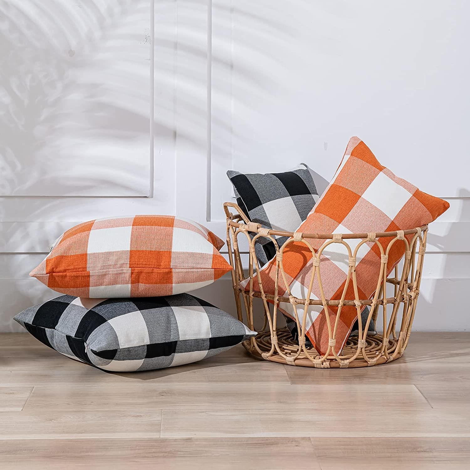 four throw pillows in orange and black plaid