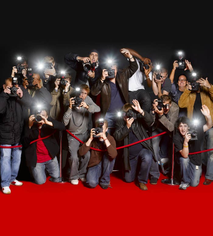 stock photo of paparazzi preparing to take photos on a red carpet