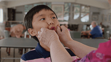 GIF of someone squeezing boy&#x27;s cheeks