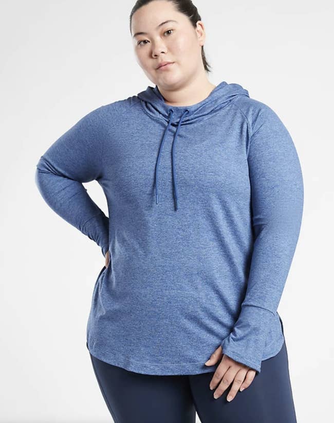 Model in a blue hoodie with thumbholes