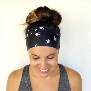 Model in a black headband wrap with white birds on it 