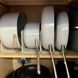 pans and pots placed in the magnetic racks in writer Kayla's cabinet
