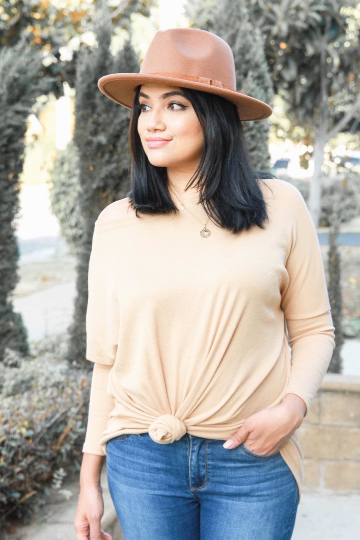 Reviewer wearing beige long sleeve shirt with high neck