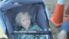 A kid in a stroller looks very confused