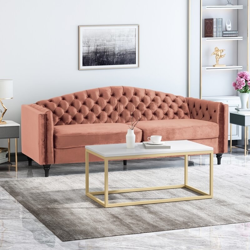 the sofa in rose with a coffee table in front of it