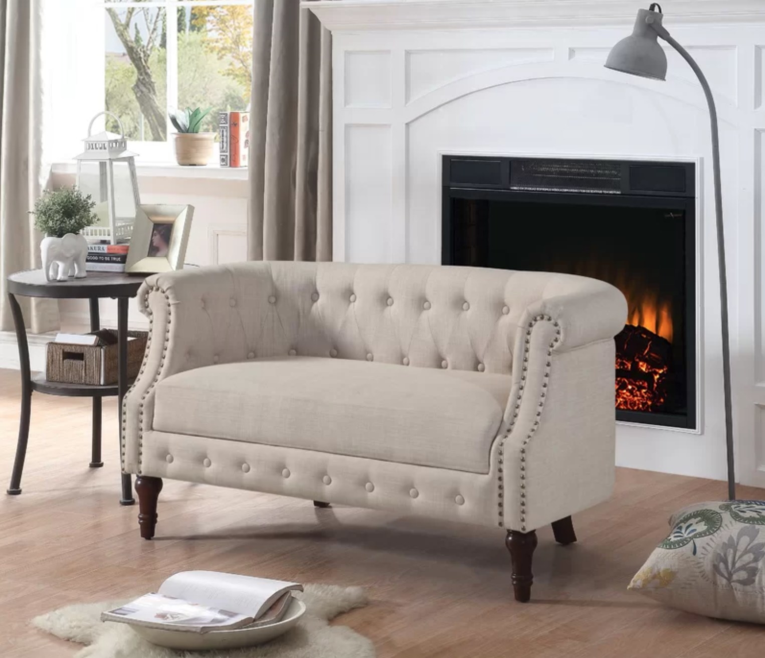 the beige loveseat in front of a fireplace