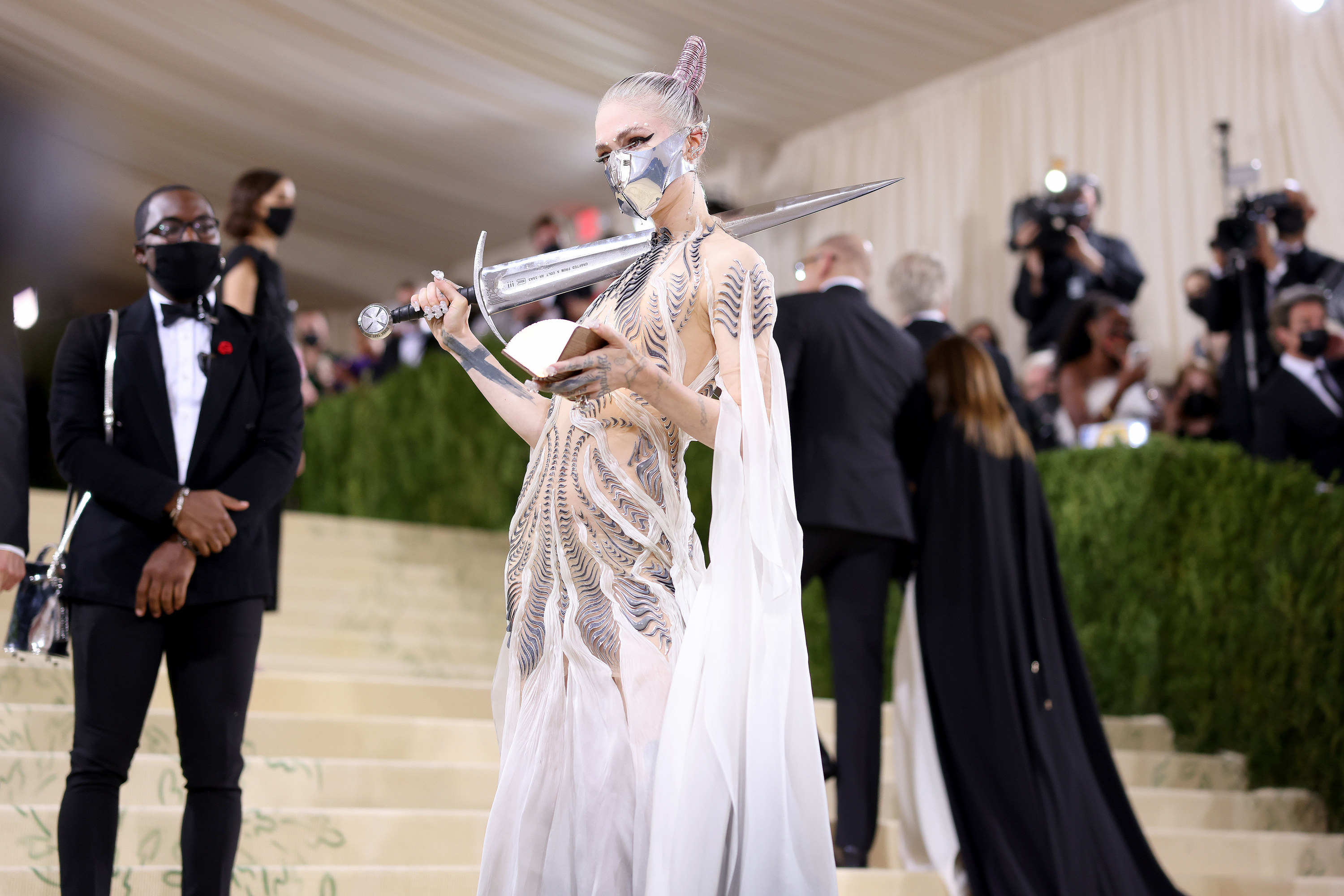 Grimes holds the sword, leaning it on her shoulder