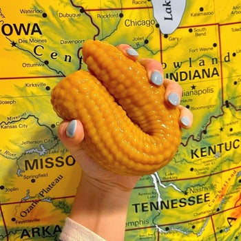 Model bending yellow corn-shaped dildo
