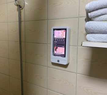 Reviewer photo of the shower mount with a phone inside playing music