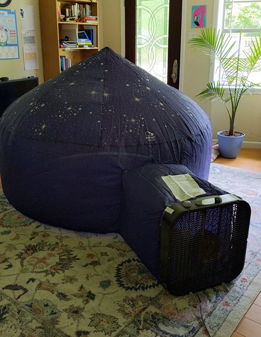 Reviewer photo of an inflatable fort with a box fan attached