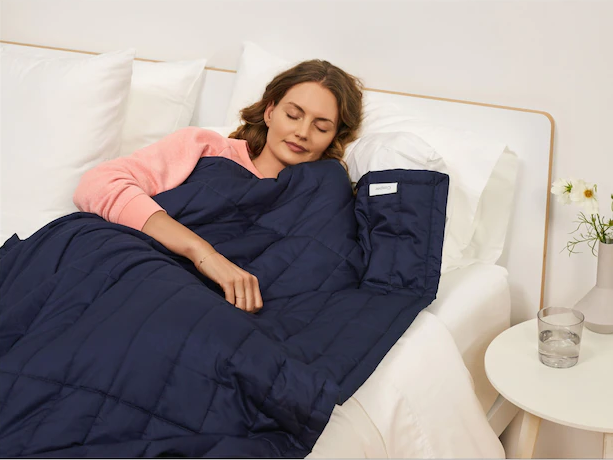 A person sleeping in a bed with a thick blanket over top of them