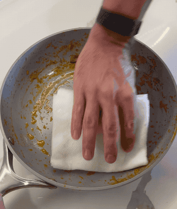 gif of pan being cleaned with just a paper towel and most of the food disappearning