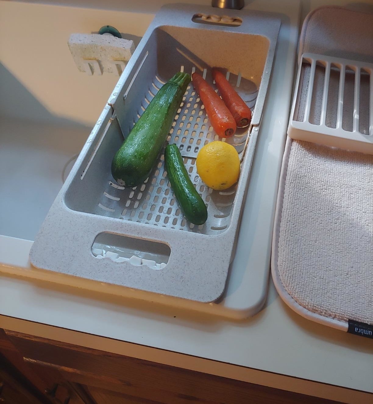 Reviewer photo of the strainer over a sink with a few vegetables in it