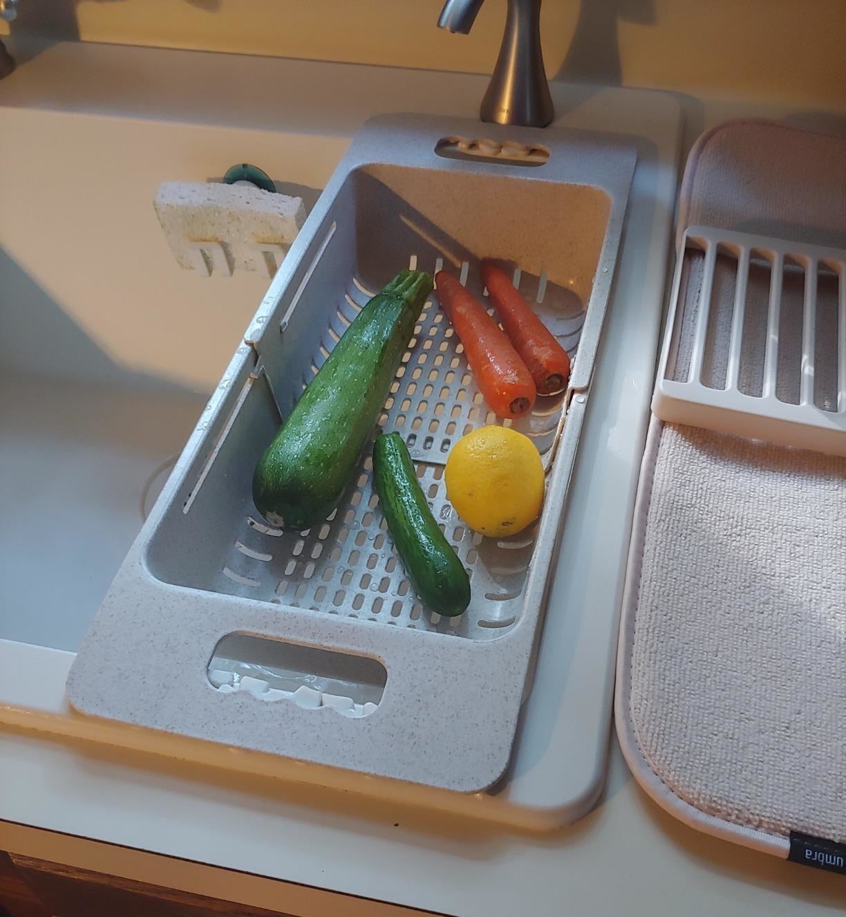 Reviewer photo of the strainer over a sink with a few vegetables in it