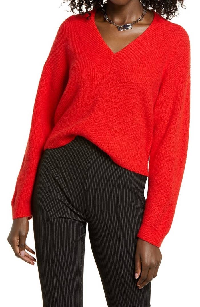 a model in a red v-neck sweater