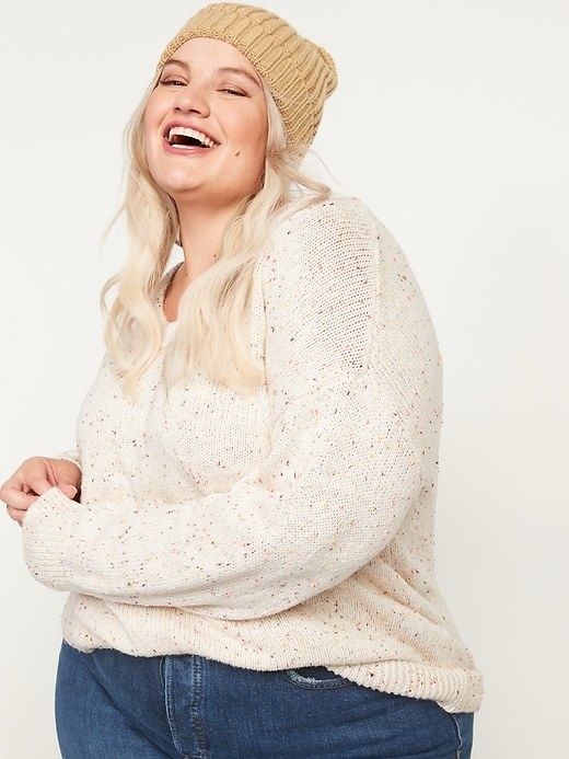 a model in a cream colored sweater with speckles on it