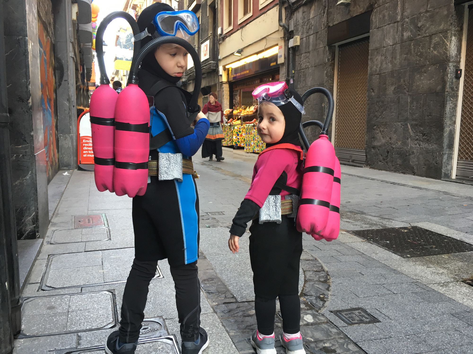 Two children dressed as scuba divers with mock air tanks.