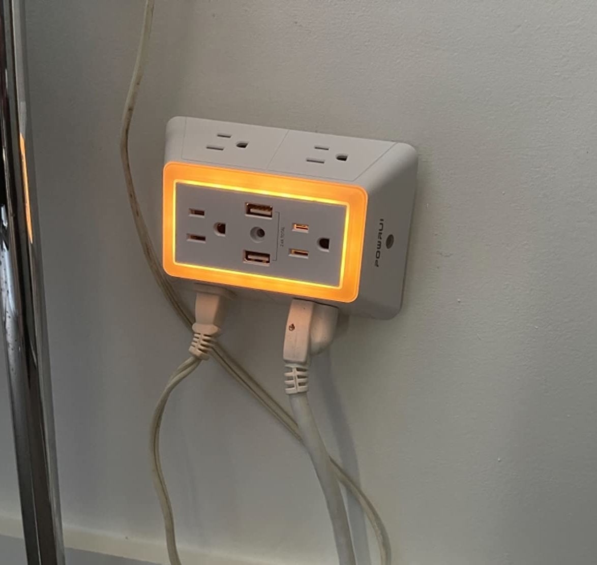 Reviewer photo of the multi-plug outlet with a couple of plugs in it