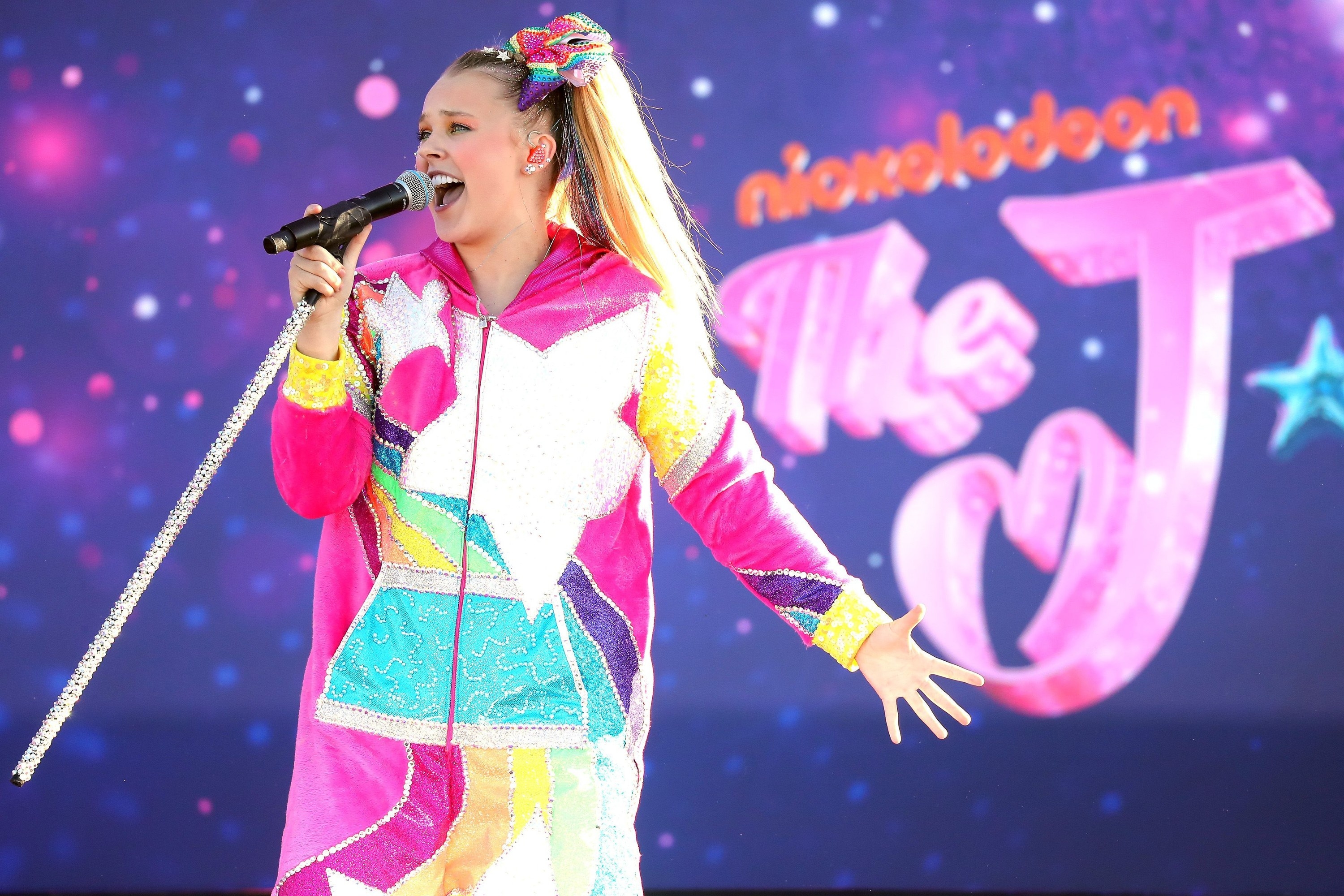 JoJo Siwa performing in a brightly colored outfit