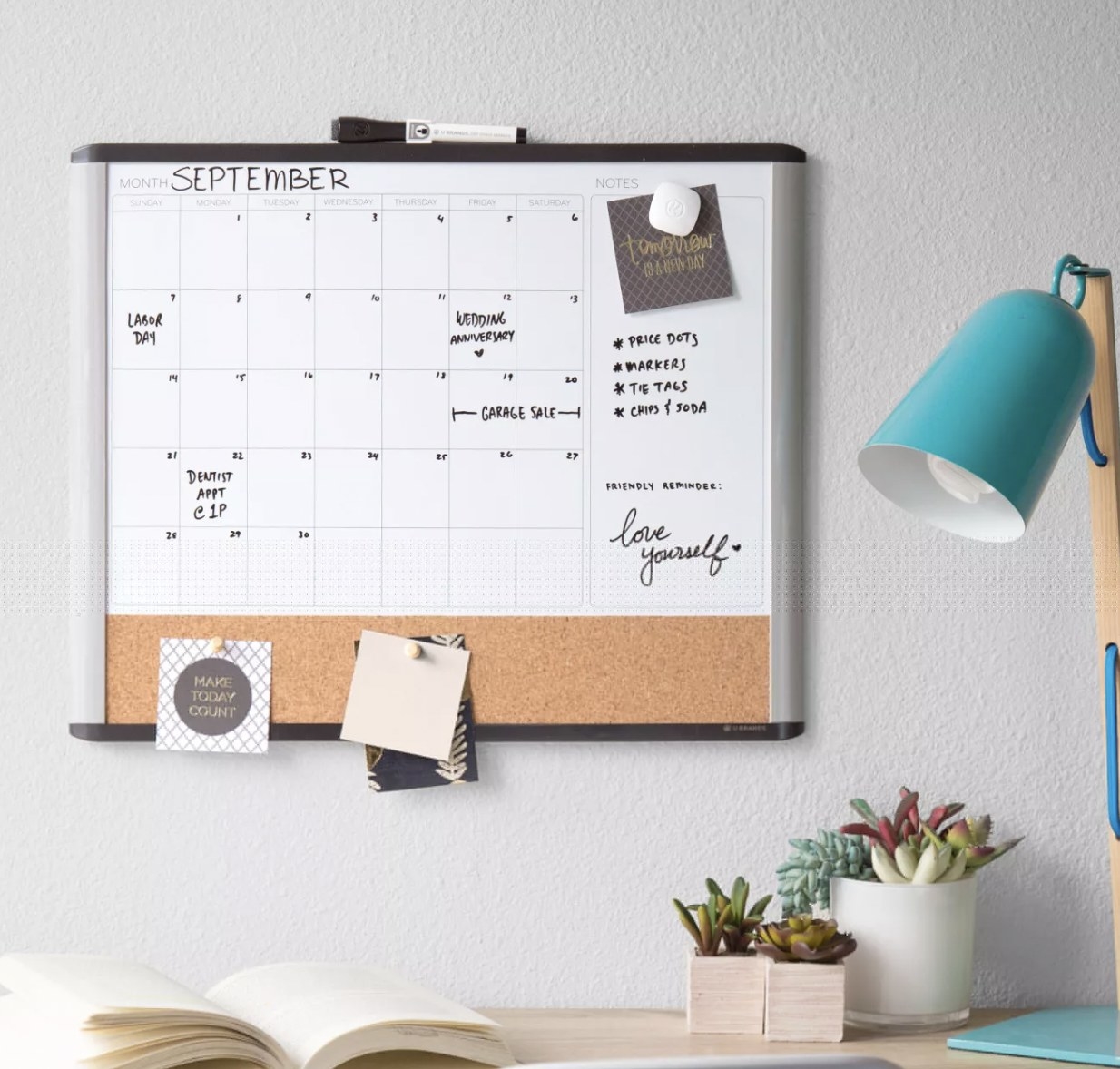 a dry-erase calendar board hanging above a bed