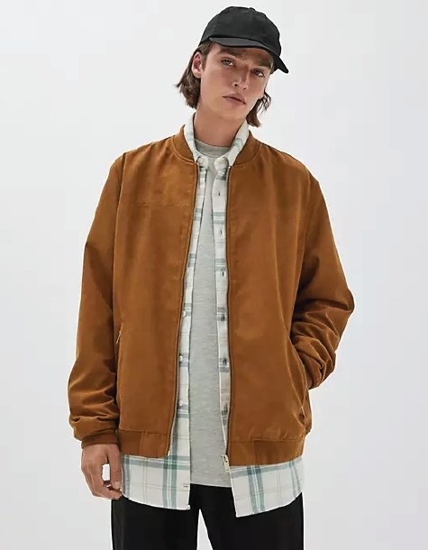 Male model wearing the zip up jacket over a gray t-shirt and flannel