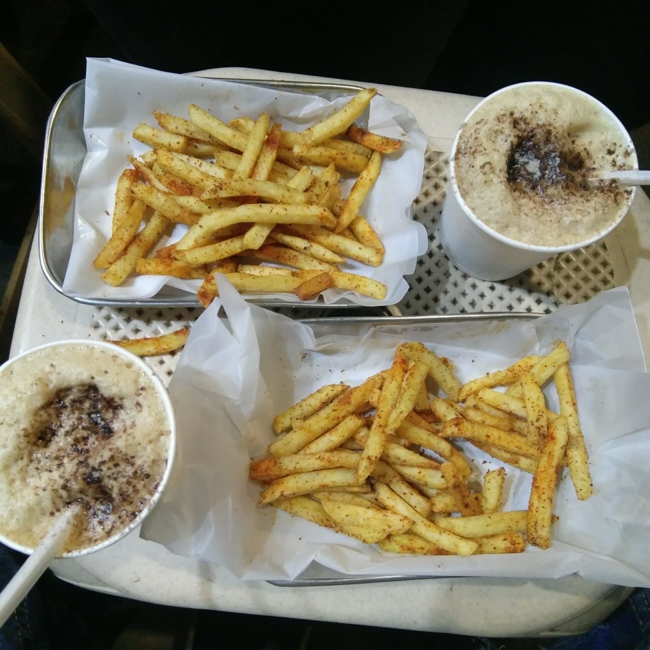 Iced coffees and fries on a plastic table