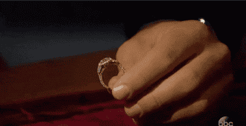 person holding a glittering diamond ring