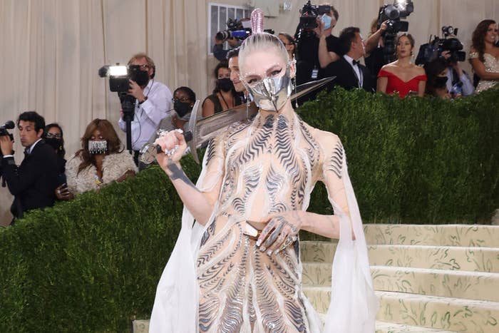 Grimes arriving at the 2021 Met Gala and carrying a sword